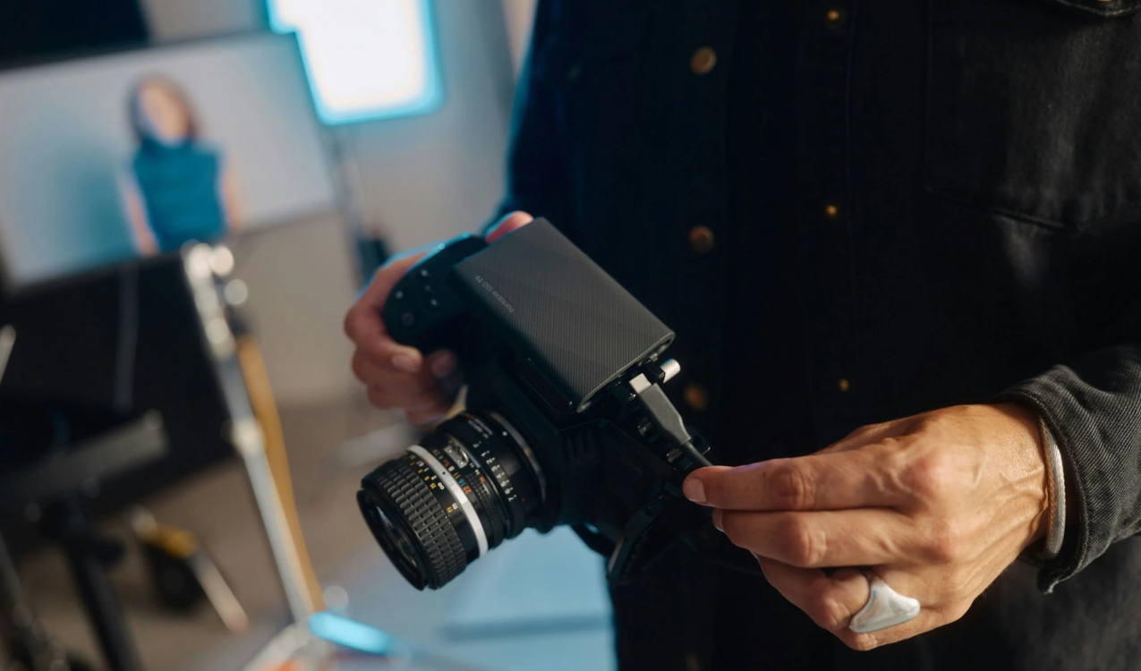 A man holding a camera in his hands scaled.jpg